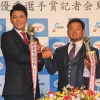 Central League MVP Hayato Sakamoto (left) of the Yomiuri Giants and Pacific League MVP Tomoya Mori of the Seibu Lions pose for photos at a Tokyo news conference after the NPB Awards on Tuesday. | KAZ NAGATSUKA