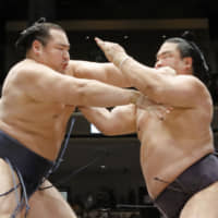 Yokozuna Kakuryu (left) competes against Myogiryu during the Summer Grand Sumo Tournament on May 22 at Ryogoku Kokugikan. | KYODO