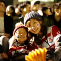 Ryoko Tokuda, 34, and her 5-year-old daughter Rinako attend a public viewing of the Rugby World Cup final match Saturday at Prince Chichibu Memorial Stadium. | RYUSEI TAKAHASHI