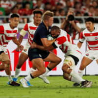 Japan captain Michael Leitch, (second from right), seen competing against Scotland\'s Chris Harris in a Rugby World Cup Pool A match on Oct. 13 in Yokohama, and his Brave Blossoms teammates will participate in a parade on Dec. 11 in Tokyo. | REUTERS