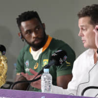 South Africa\'s Siya Kolisi looks at coach Rassie Erasmus at a news conference after the team defeated England in the Rugby World Cup final at International Yokohama Stadium in the city on Saturday. | AP