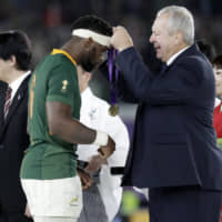 World Rugby chairman Bill Beaumont (right) presents the winners\' medal to South Africa captain Siya Kolisi on Saturday at International Stadium Yokohama. | AP
