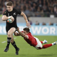 New Zealand\'s Beauden Barrett runs past Wales\' Josh Adams during the Rugby World Cup bronze-medal match on Friday at Tokyo Stadium. | AP