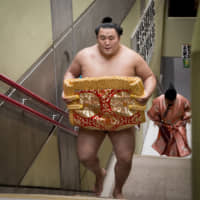 Tamawashi carries his keshō-mawashi (ceremonial apron-style belt) during a regional tour event in Misato, Saitama Prefecture, on April 10, 2015. | JOHN GUNNING