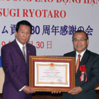 The Third Class Labor Medal of the Socialist Republic of Vietnam was given to Japanese actor and singer Ryotaro Sugi (left) given by Vietnam Ambassador Vu Hong Nam (right) for 30 years of charity concerts and welfare activities contributing to establishing a relationship between Japan and Vietnam, at the embassy on Oct. 30. | YOSHIAKI MIURA