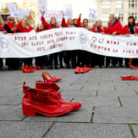 Red shoes are placed on the ground in central Brussels on Sunday during a demonstration against violence toward women. Police said about 10,000 people attended the protest, which took place on the eve of the International Day for the Elimination of Violence Against Women. | REUTERS