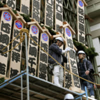 Workers put up wooden nameplates for kabuki actors at the Minamiza Theater in Kyoto on Monday ahead of year-end performances, which will begin Saturday and run through Dec. 26. | KYODO