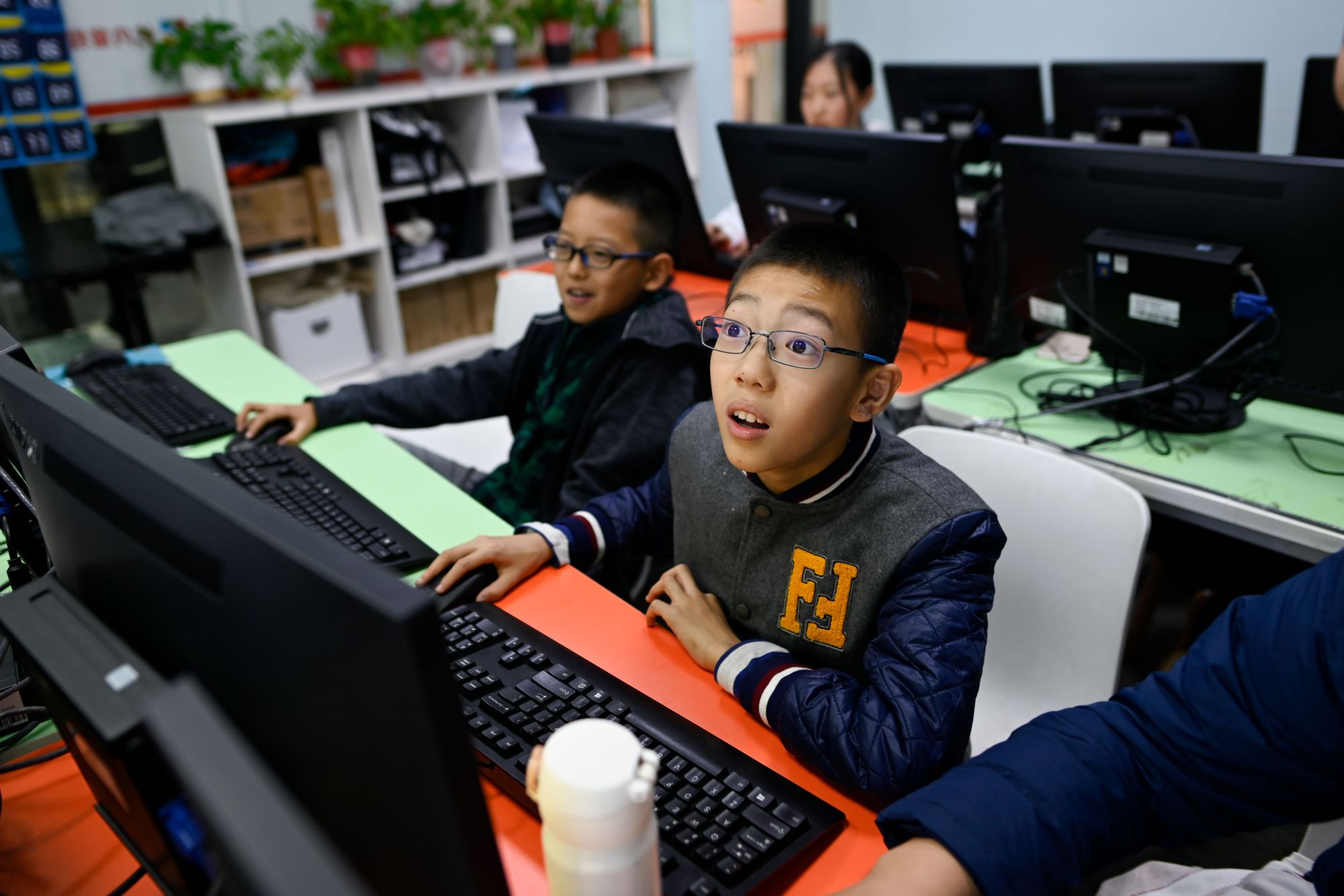 Pupils attend a class at a children's computer coding training center in Beijing on Nov. 8. China has been making huge investments in robotics and artificial intelligence, with the government issuing in 2017 an AI development plan that suggested programming courses be taught in both primary and secondary schools. | AFP-JIJI