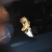 Carlos Ghosn, former chairman of Nissan Motor Co., sits in a vehicle after visiting his lawyer\'s office in Tokyo in March. | BLOOMBERG