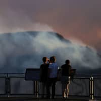 Smoke from the Green Wattle Creek fire is seen from Echo Point lookout in Katoomba, New South Wales, on Friday. | AAP / VIA REUTERS
