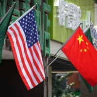 The U.S. and Chinese flags fly displayed outside a hotel in Beijing in May. The United States secretly expelled two Chinese Embassy officials in September after they drove onto a sensitive military base in Virginia, The New York Times reported Sunday. The newspaper, which cited people with knowledge of the episode, said it appeared to be the first time in more than 30 years that the U.S. has expelled Chinese diplomats on suspicion of espionage. | AFP-JIJI