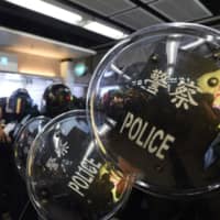 Police stand guard during a protest at the New Town Plaza shopping mall in Shatin in Hong Kong on Sunday. | AFP-JIJI