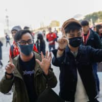 Hong Kongers demonstrate before a soccer match between Hong Kong and China outside Busan Asiad Stadium in Busan, South Korea, on Wednesday. | REUTERS