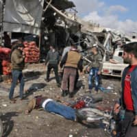 Bodies lie on the ground following a regime airstrike Monday on a market in the town of Maaret al-Numan in the jihadi-run Syrian province of Idlib. | AFP-JIJI