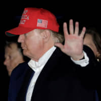 U.S. President Donald Trump waves after disembarking Air Force One upon arriving in Joint Base Andrews in Maryland on Sunday after his Thanksgiving vacation. | REUTERS
