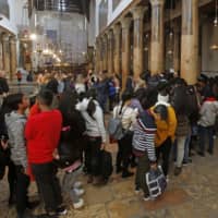 Christian tourists visit the Church of the Nativity in the biblical West Bank city of Bethlehem on Saturday. The city where Christians believe Jesus was born is teeming with tourists &#8212; but the Christmas spirit is dampened by complaints that Israeli tour operators don\'t allow the city to truly benefit from the influx. | AFP-JIJI