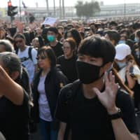 Anti-government protesters hold up five fingers, representing their five demands, during the \"Lest We Forget\" rally in Kowloon in Hong Kong on Sunday. | REUTERS