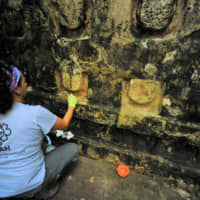 An archaeologist works cleaning the stucco of the Temple of the U, located in the archaelogy area of Kuluba, in Tizimin, Yucatan state, Mexico, in this photo released Tuesday. | NATIONAL INSTITUTE OF ANTHROPOLOGY AND HISTORY / HANDOUT / VIA REUTERS