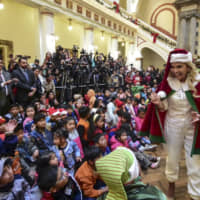 Bolivian interin President Jeanine Anez is dressed as Santa Claus during a Christmas celebration at the Quemado presidential palace in La Paz Tuesday. | BOLIVIA\'S PRESIDENTIAL MINISTRY OFFICIAL TWITTER ACCOUNT @MINPRESIDENCIA / VIA AFP-JIJI