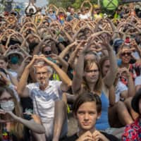 A climate protest in Sydney on Thursday. Protesters marched on Prime Minister Scott Morrison\'s official residence to demand curbs on greenhouse gas emissions and highlight his absence on an overseas holiday as bush fires burned across the region. | AFP-JIJI