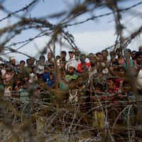 Rohingya refugees gather in the \"no man\'s land\" behind Myanmar\'s border lined with barb wire fences in the Maungdaw district, Rakhine state, bounded by Bangladesh last year. | AFP-JIJI