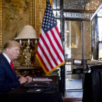 President Donald Trump pauses during a Christmas Eve video teleconference with members of the military at his Mar-a-Lago estate in Palm Beach, Florida, Tuesday. | AP