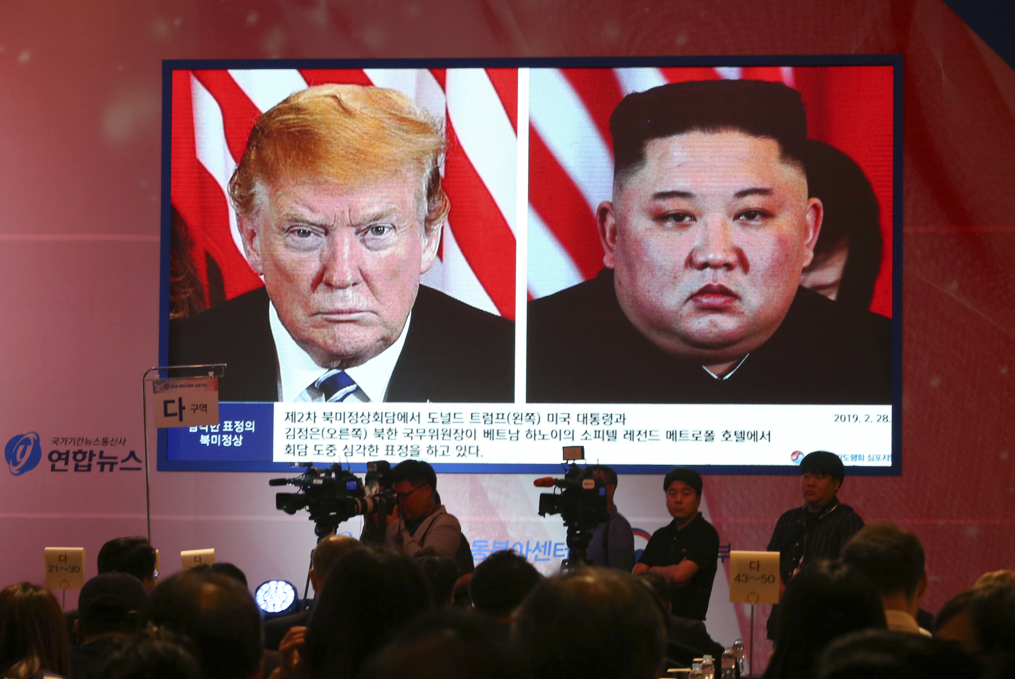 A large display screen shows North Korean leader Kim Jong Un and U.S. President Donald Trump during a symposium in Seoul in June. | AP