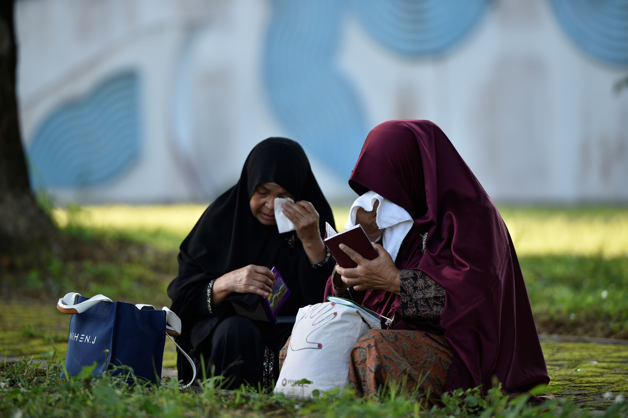 Tsunami survivor Nurhayati (right), 65, prays at a cemetery containing mass graves in Siron, Indonesia, in Aceh province, on Thursday. | AFP-JIJI