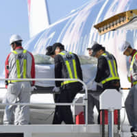The coffin of slain Japanese doctor Tetsu Nakamura is carried by airline workers Monday at Fukuoka airport in the city of Fukuoka, his hometown. | KYODO