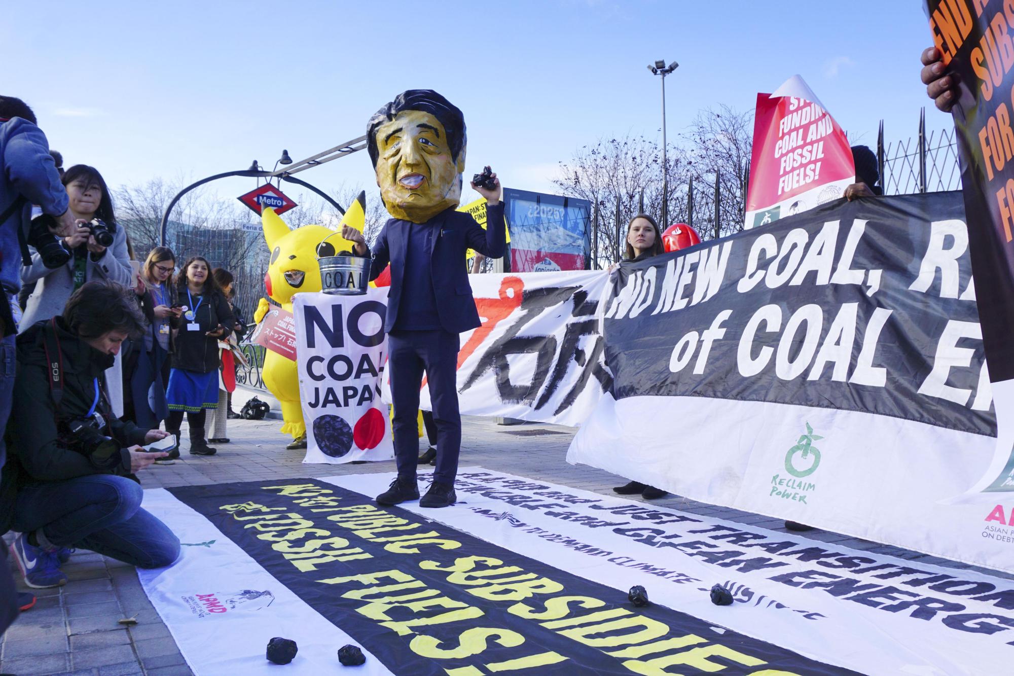 Members of environmental groups stage a protest near the venue of a U.N. Climate Change Conference, known as COP25, in Madrid on Thursday, calling for Japan to abolish coal-fired power generation. | KYODO