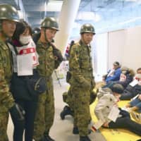 An earthquake drill is held at the Ariake Gymnastics Centre, a venue for the 2020 Tokyo Olympics and Paralympics, on Thursday. | KYODO