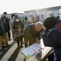 Residents receive keys to temporary housing units in Marumori, Miyagi Prefecture, on Saturday. Emperor Naruhito and Empress Masako are set to visit Marumori and other typhoon-devastated areas on Thursday. | KYODO