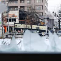A file photo from last Dec. 17 shows the site of a major explosion in Sapporo through the shattered windows of a nearby clinic. | KYODO