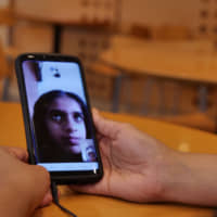 Sri Lankan national Dakshini Siriwardena, 21, talks on Skype with her younger sister, Pamalya, who left Japan after her father\'s business failure, on June 6. | CHISATO TANAKA