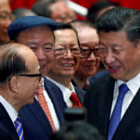 Chinese President Xi Jinping is greeted by tycoon Li Ka-shing before a photo session during Xi\'s visit to Hong Kong in June 2017. | REUTERS