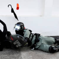 A riot police officer tries to subdue a protester during an anti-government demonstration in Hong Kong on Nov. 10. | REUTERS
