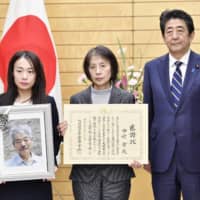 Naoko Nakamura (center), the widow of slain physician Tetsu Nakamura, poses with their daughter Akiko and Prime Minister Shinzo Abe at the Prime Minister\'s Office in Tokyo on Friday. | KYODO