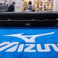 People try Mizuno Corp. shoes at the company\'s flagship sporting goods store in Tokyo. | BLOOMBERG