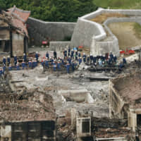 Police officers and firefighters inspect Shuri Castle in Naha, Okinawa Prefecture, on Nov. 1, a day after the castle burned down in a fire. | KYODO