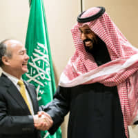 Masayoshi Son, chairman and chief executive officer of SoftBank Group Corp., and Mohammed bin Salman, Saudi Arabia\'s crown prince, talk after the signing of a solar energy plan in New York in March 2018. | BLOOMBERG