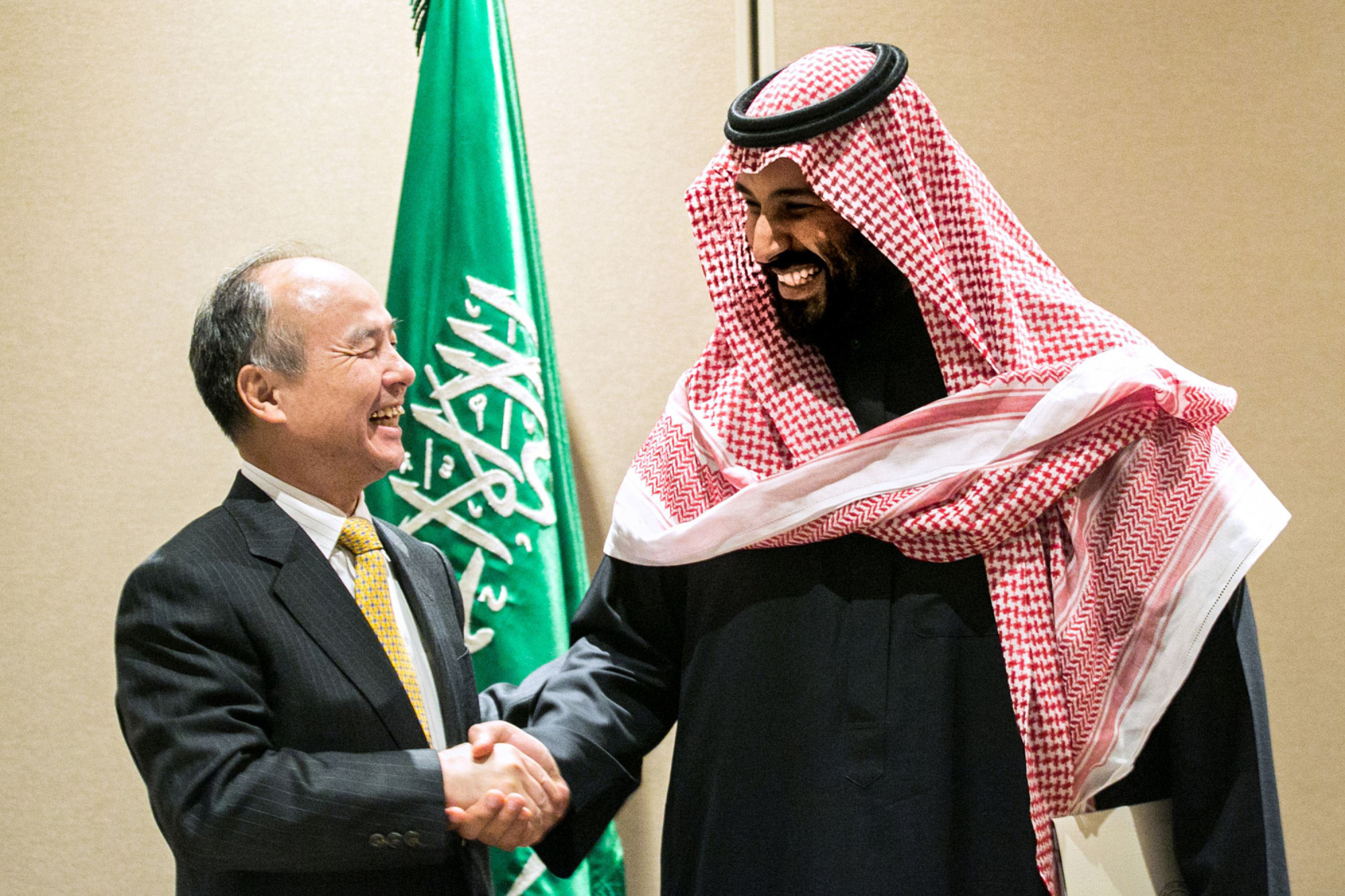 Masayoshi Son, chairman and chief executive officer of SoftBank Group Corp., and Mohammed bin Salman, Saudi Arabia's crown prince, talk after the signing of a solar energy plan in New York in March 2018. | BLOOMBERG