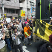 Speak out: Koenji\'s counter-cultural vibe attracted those tourists and visitors looking for something a little less neon in their Tokyo experience. In this 2011 photo, Rankin\' Taxi leads one of the first post-Fukushima antinuclear demonstrations. | JAMES HADFIELD