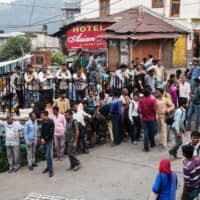 Laborers wait on the side of the road to be hired for the day in Dharamshala, India. Unemployment hit a record high this year in the world\'s second most populous nation, where the median age is 28. | BLOOMBERG