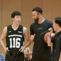 Golden State Warriors star Stephen Curry (second from right), seen during his June visit to Tokyo, collaborated with Rakuten on a short documentary about basketball in Japan. The film made its global debut last week on Curry\'s YouTube channel. | COURTESY OF RAKUTEN