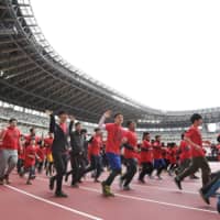 People take part in the first run on the track at the new National Stadium on Saturday. | KYODO