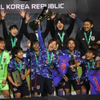 Akari Kurishima holds up the EAFF E-1 women\'s championship trophy after Japan\'s win over South Korea on Tuesday in Busan, South Korea. | AFP-JIJI