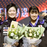 Miyu Kihara (left) and Miyu Nagasaki show off their medals after winning the women\'s doubles tourmanet at the ITTF World Tour Grand Finals on Sunday in Zhengzhou, China. | KYODO