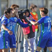 Tokushima Vortis forward Atsushi Kawata (center) celebrates with teammates after scoring against Montedio Yamagata in a promotion playoff match on Sunday at Pocari Sweat Stadium. | KYODO