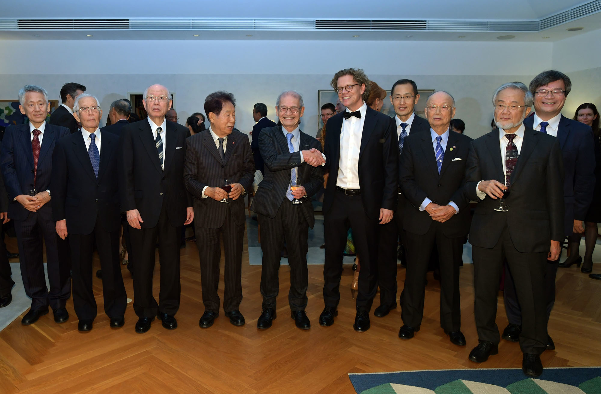 2019 winner of the Nobel Prize in chemistry Akira Yoshino shakes hands with Swedish Ambassador Pereric Hogberg  during a 