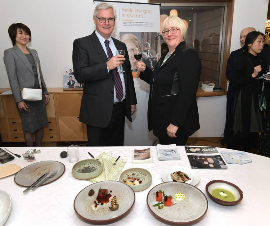 Danish Ambassador Peter Taksoe-Jensen (left) stands next to Minister-Counsellor Lene Molsted Jensen in front of a series of tableware created by 17 professional Danish craftspeople and designers during  the Designing for Health 2019 event at the Danish Embassy in Tokyo      on Nov. 29. yoshiaki miura